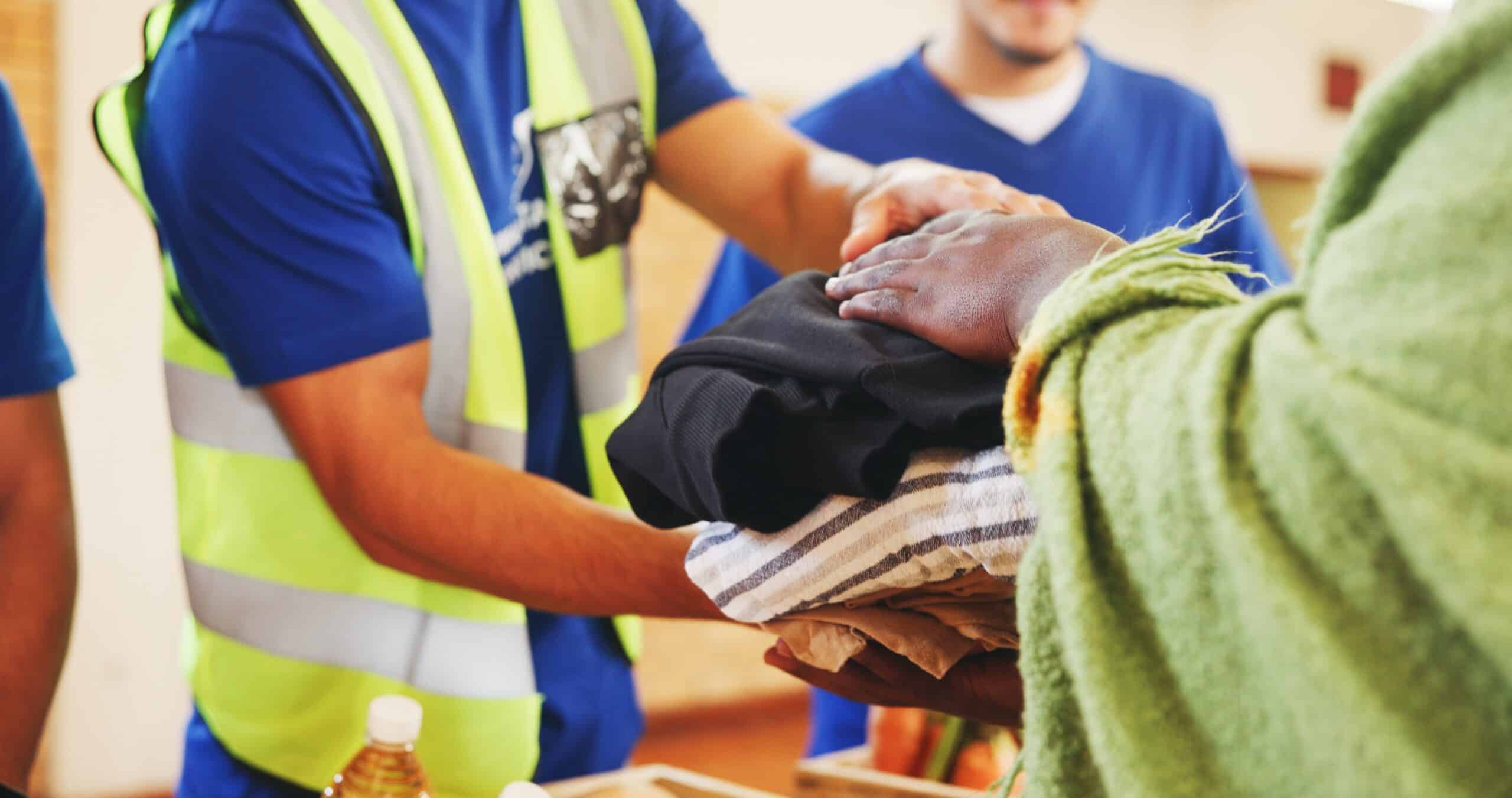Relief workers placing supplies into a person's hands